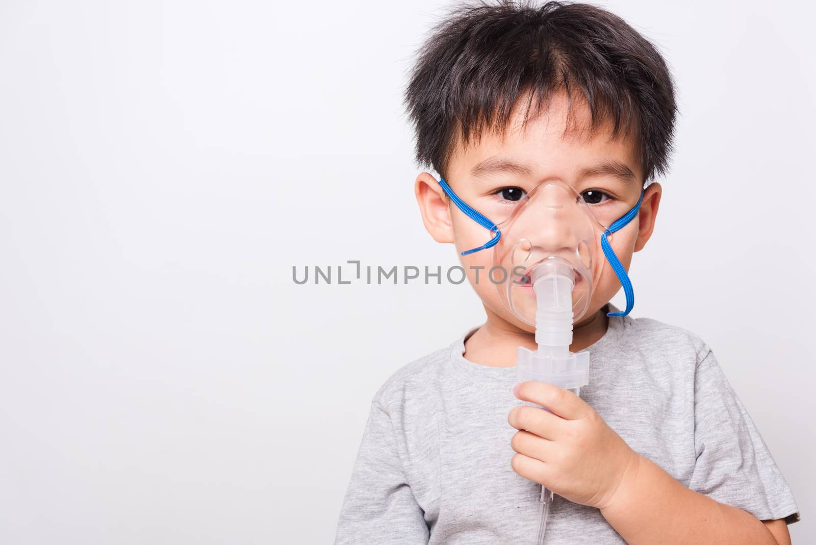 Closeup Asian face, Little children boy sick he using steam inhaler nebulizer mask inhalation oneself on white background, health medical care