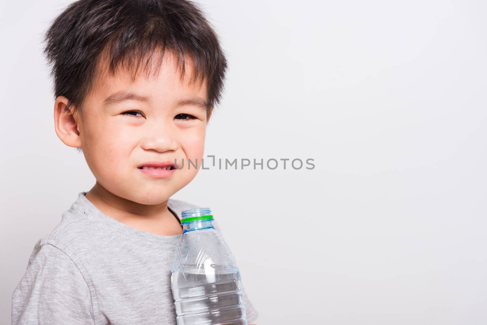 Closeup Asian face, Little children boy drinking water from Plastic bottle on white background with copy space, health medical care