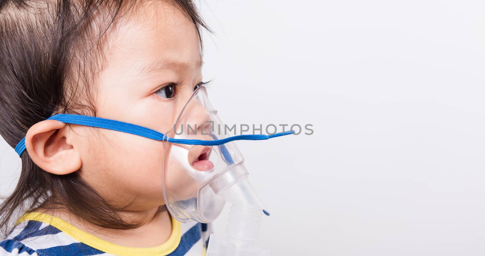 Closeup Asian face, Little baby girl sick her using steam inhaler nebulizer mask inhalation oneself on white background with copy space, health medical care