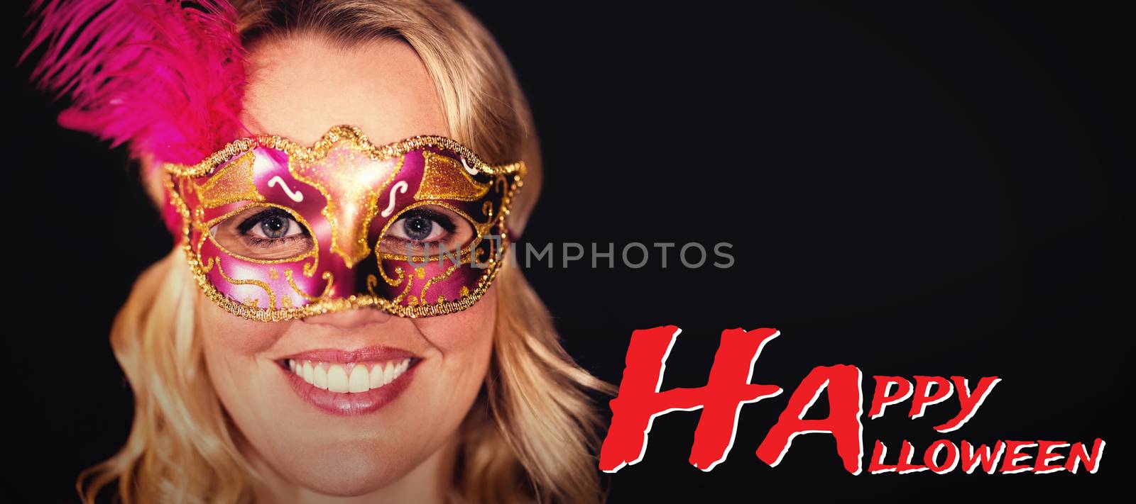 Graphic image of Happy Halloween text against portrait of happy woman in masquerade mask 
