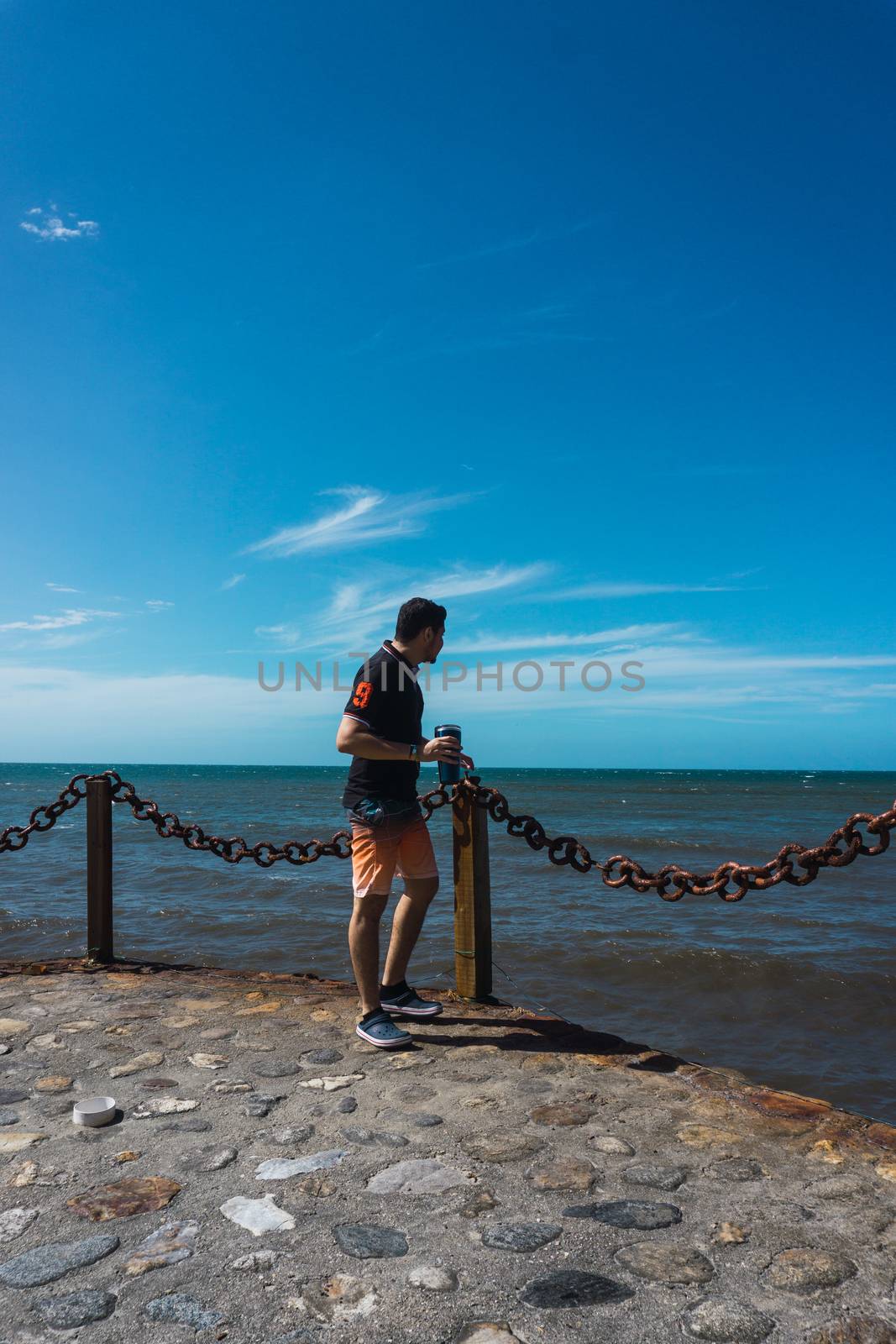 Along man on the pier enjoying the sun and the beautiful of the sea by henrry08