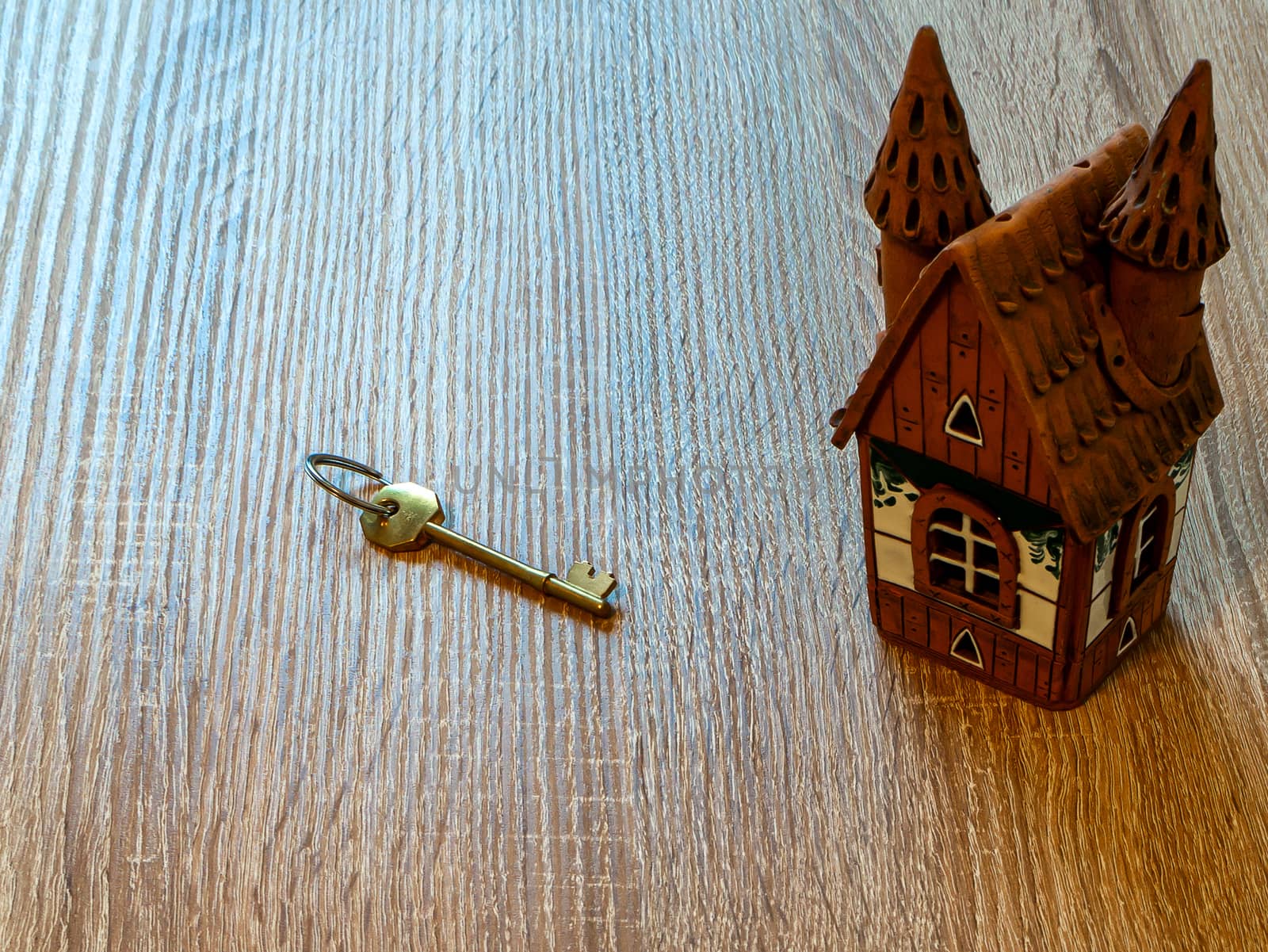 Model of a house and golden key On Wooden Table. Real estate agency, mortgage loan, lottery, buying property.Home loan and investment concept. Copy space