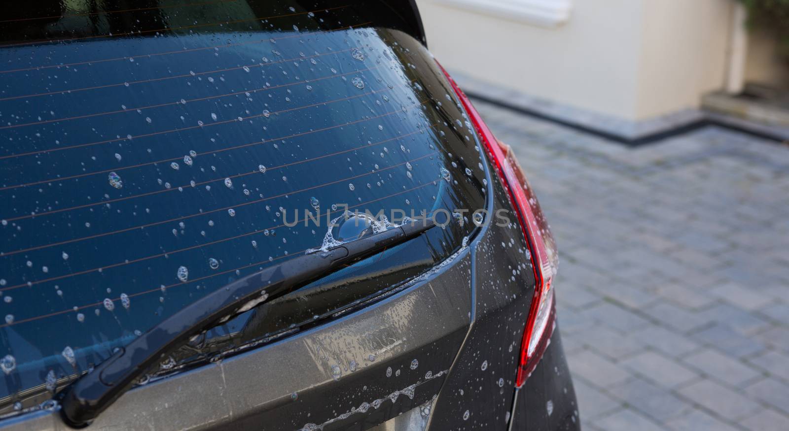 Half washed car with soap foam at outdoors