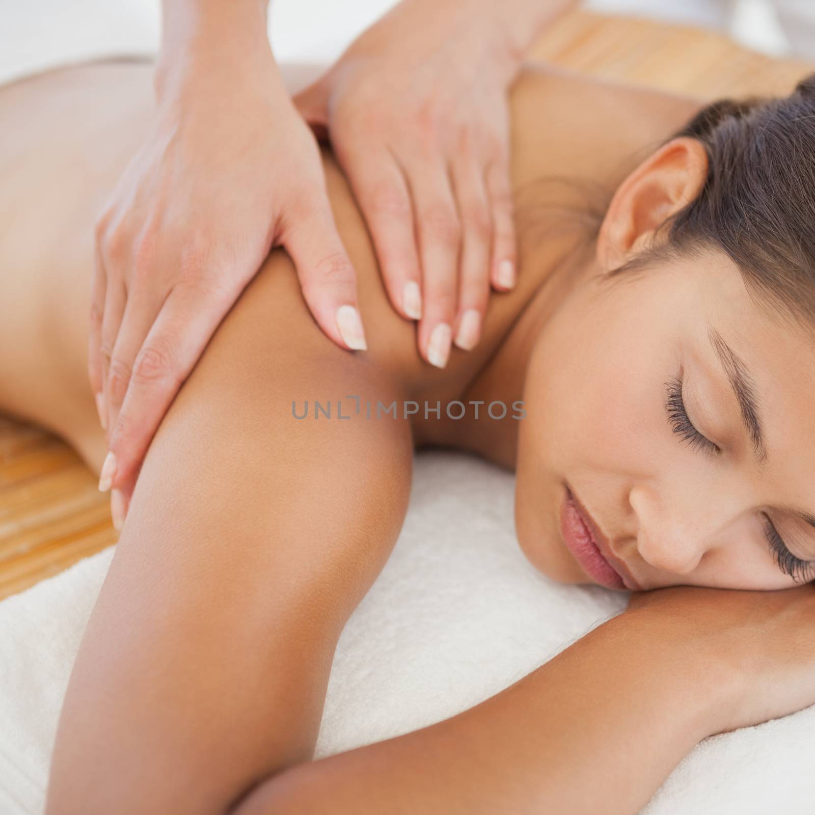 Beautiful brunette enjoying a shoulder massage  by Wavebreakmedia