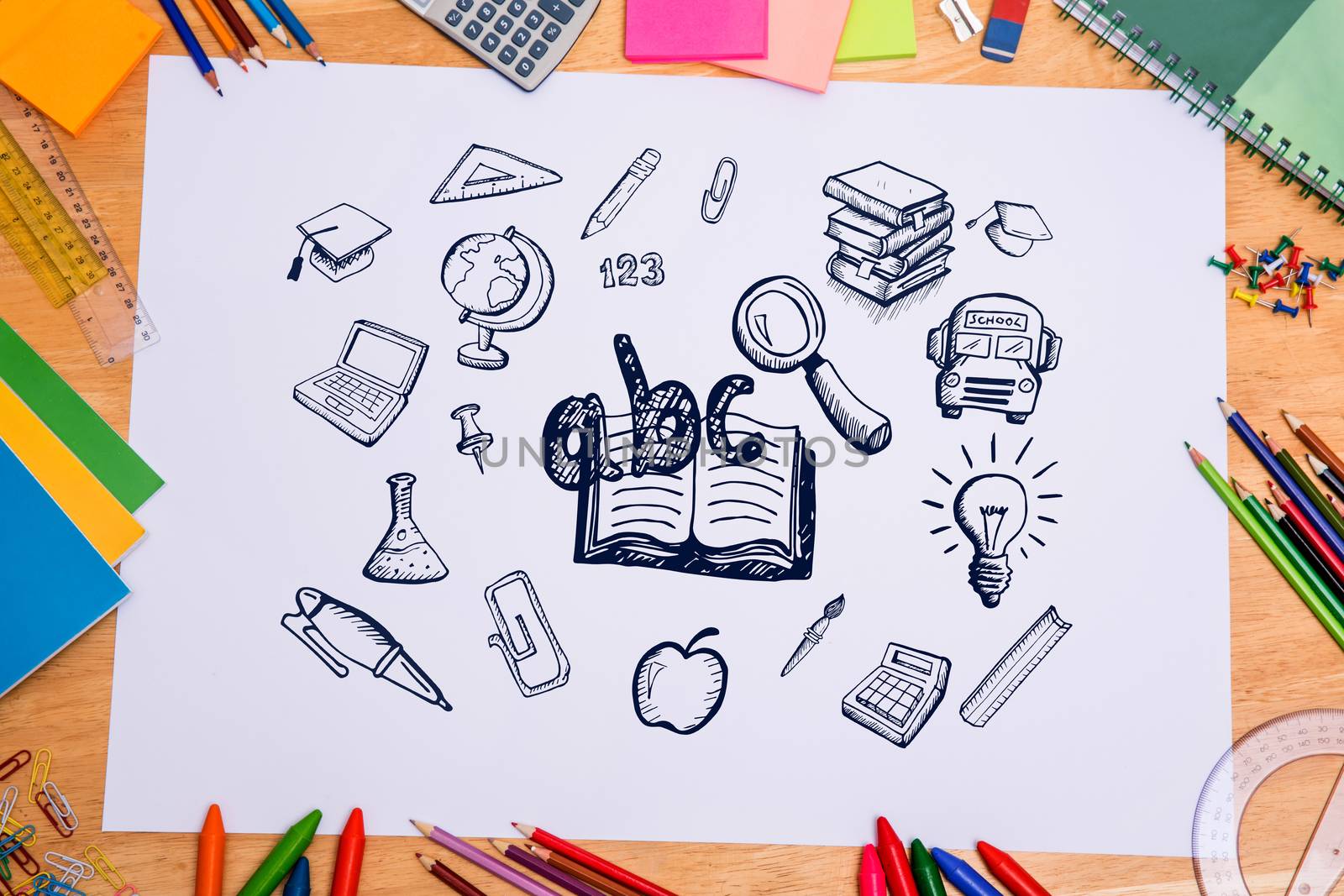 Composite image of education doodles against students desk