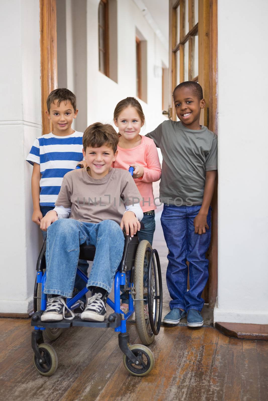 Disabled pupil with his friends in classroom at the elementary school