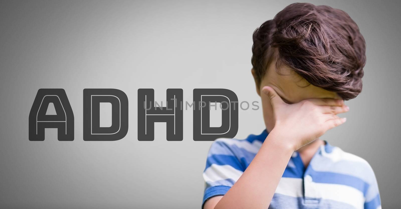 Boy against grey background with ADHD text by Wavebreakmedia