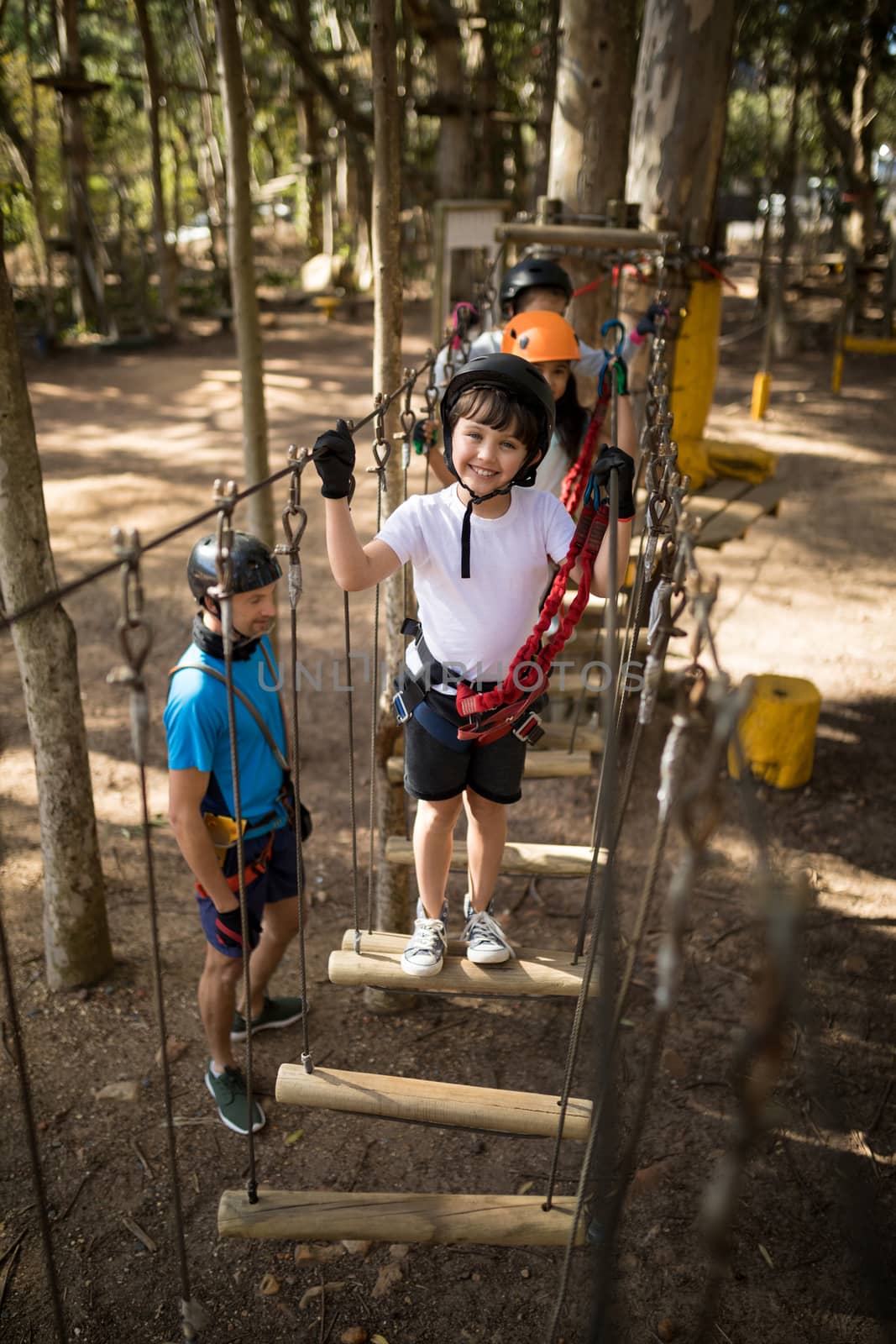 Portrait of cute boy standing on outdoor equipment in playground