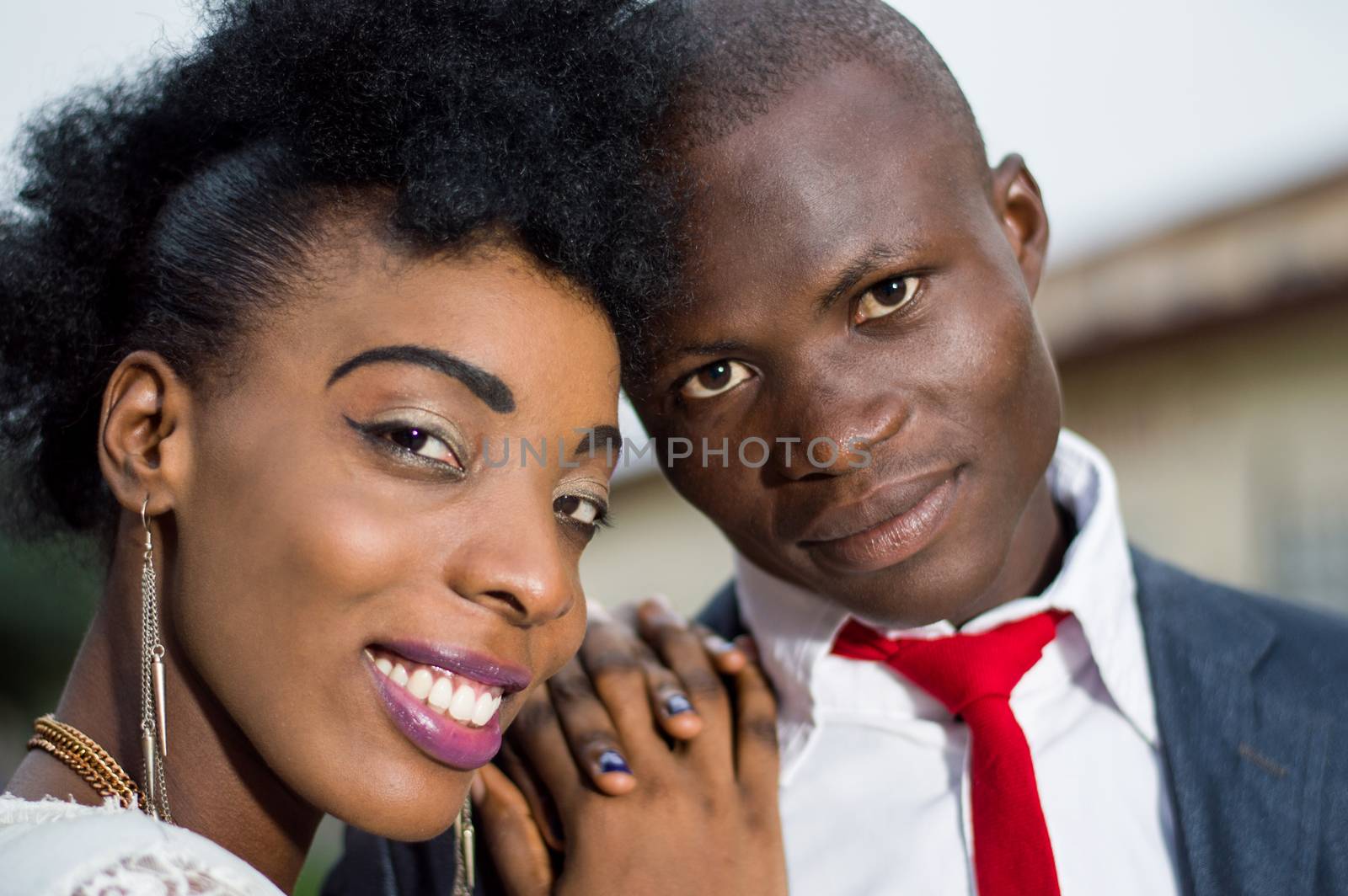 Close-up of young couple in love embracing smiling at the camera.