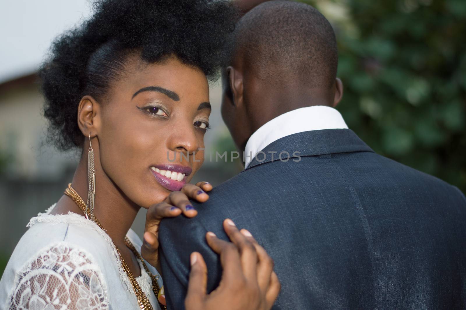 Loving couple standing out with the woman's head on his man's shoulder.