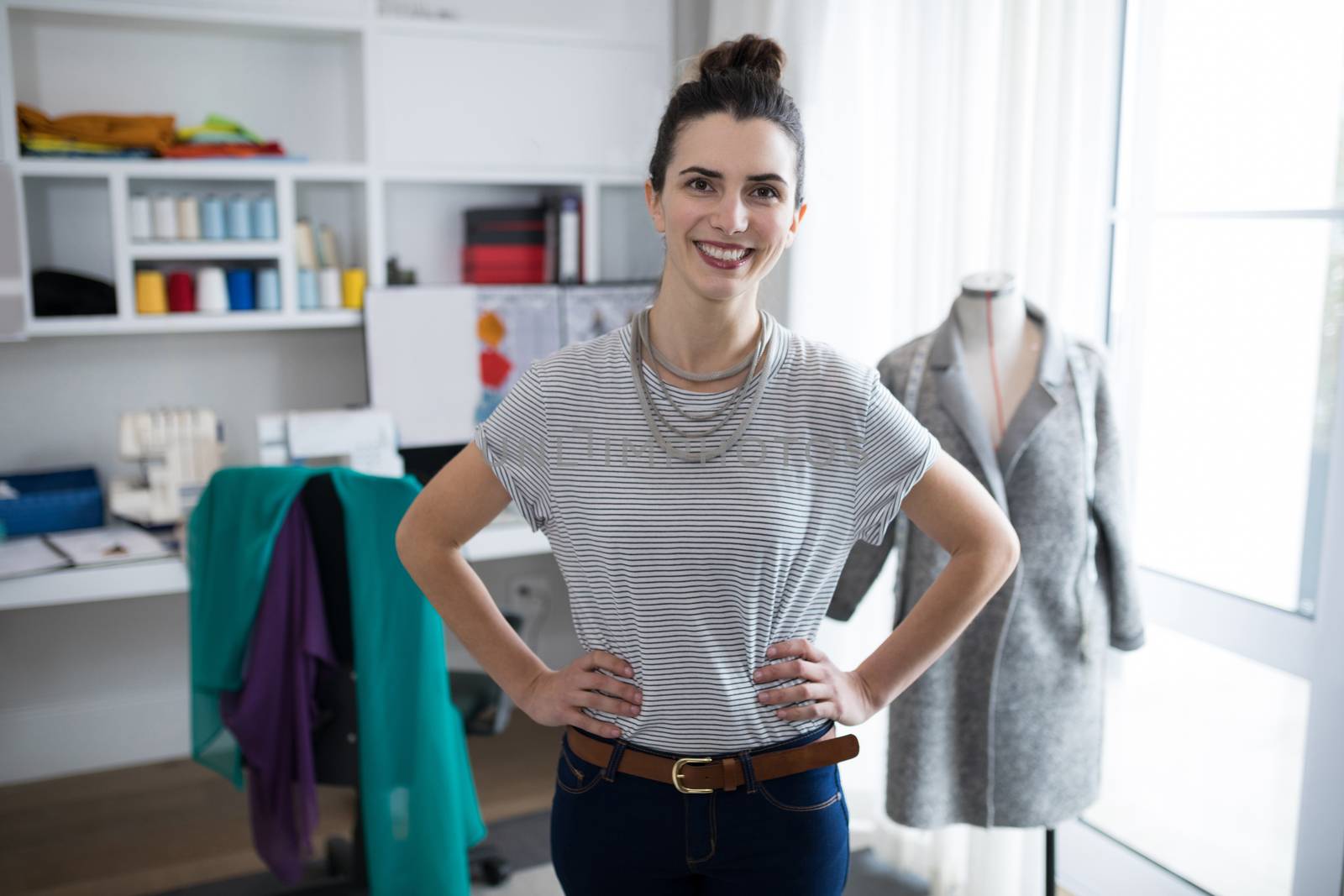 Fashion designer standing with hands on hip at home