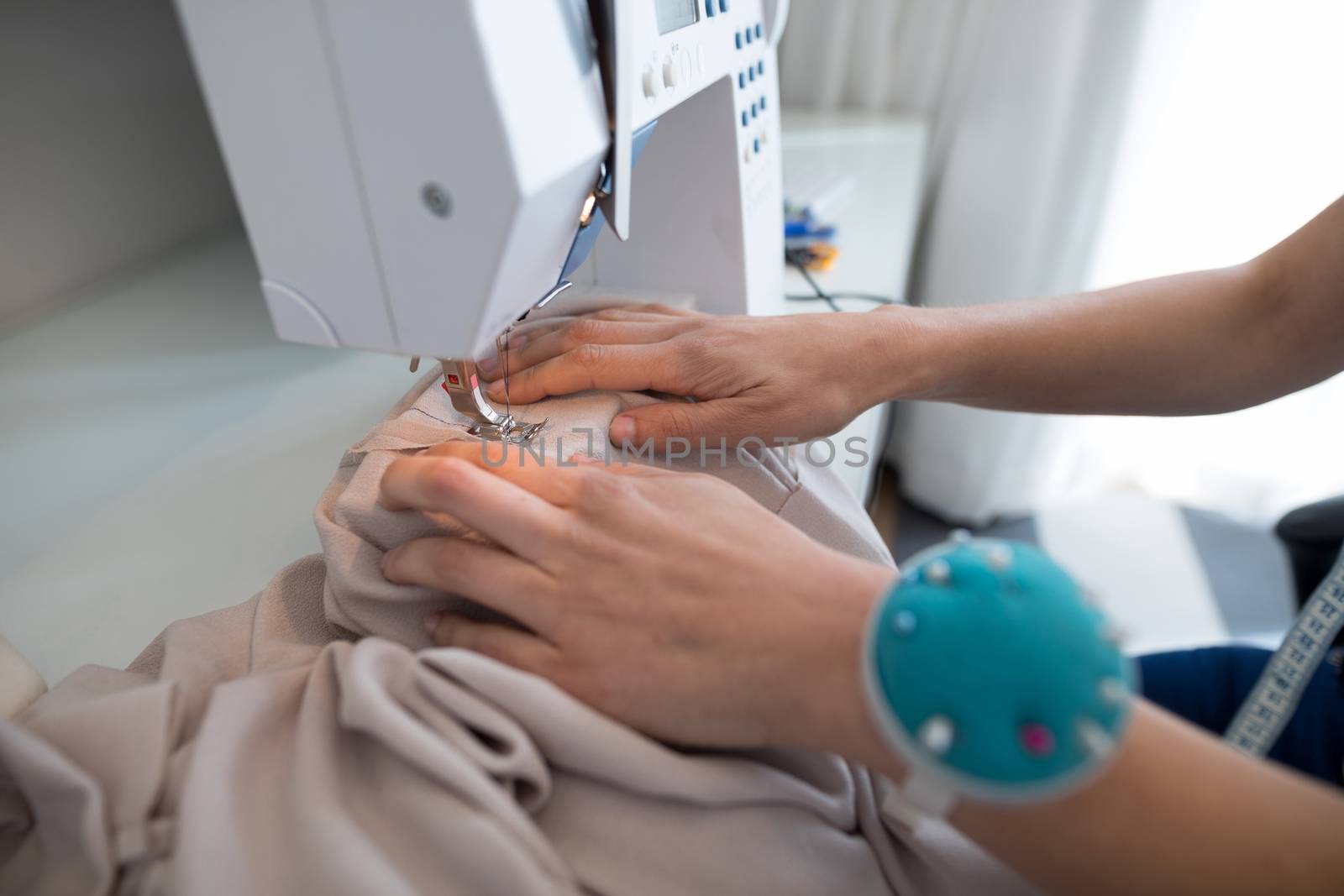 Fashion designer using sewing machine at home