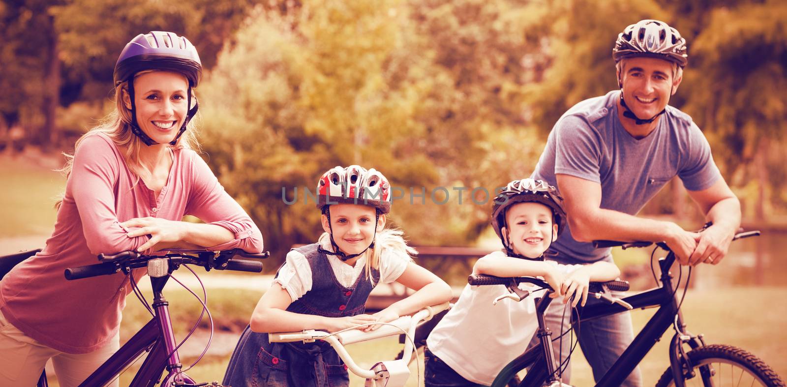 Portrait of happy family on bicycle at park