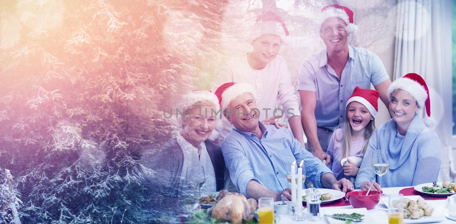 Defocused lights against snow covered trees against happy family in santa hat looking at camera