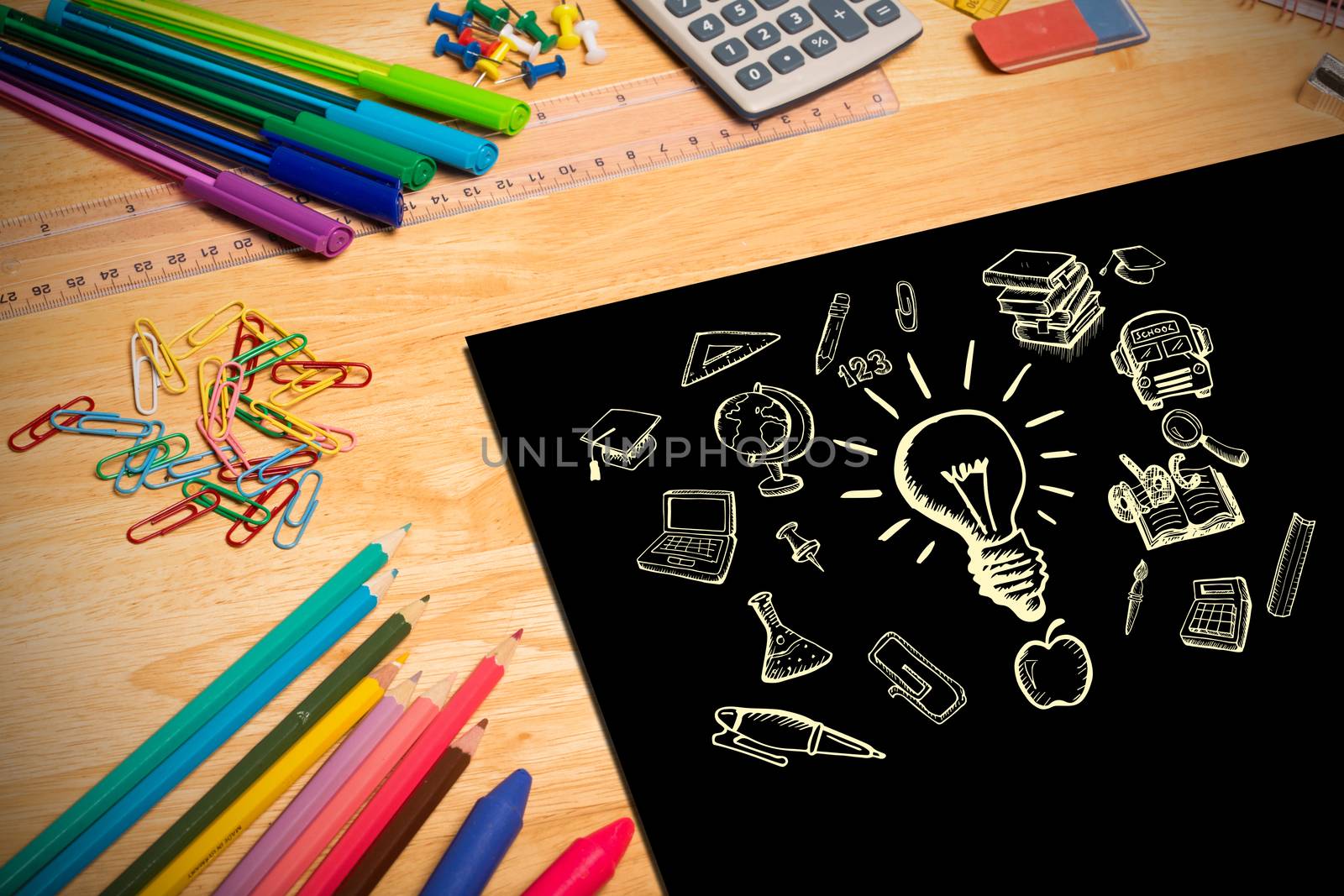 Composite image of education doodles against students desk