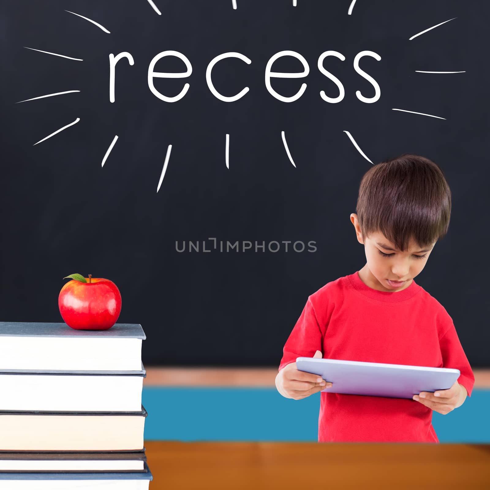 The word recess and cute boy using tablet against red apple on pile of books in classroom