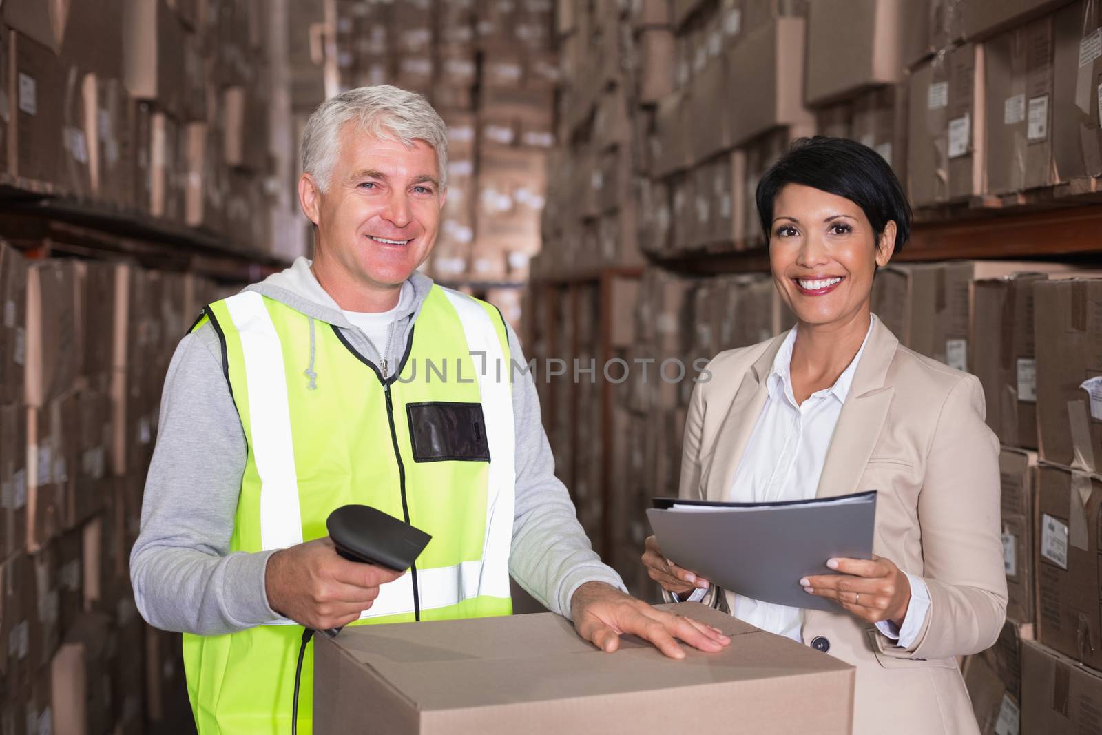 Warehouse worker scanning box with manager by Wavebreakmedia