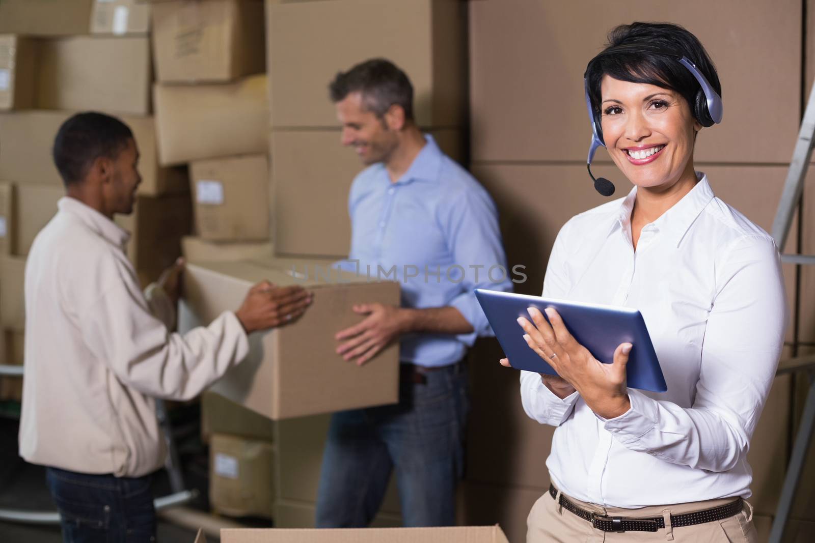 Pretty warehouse manager using tablet during busy period by Wavebreakmedia