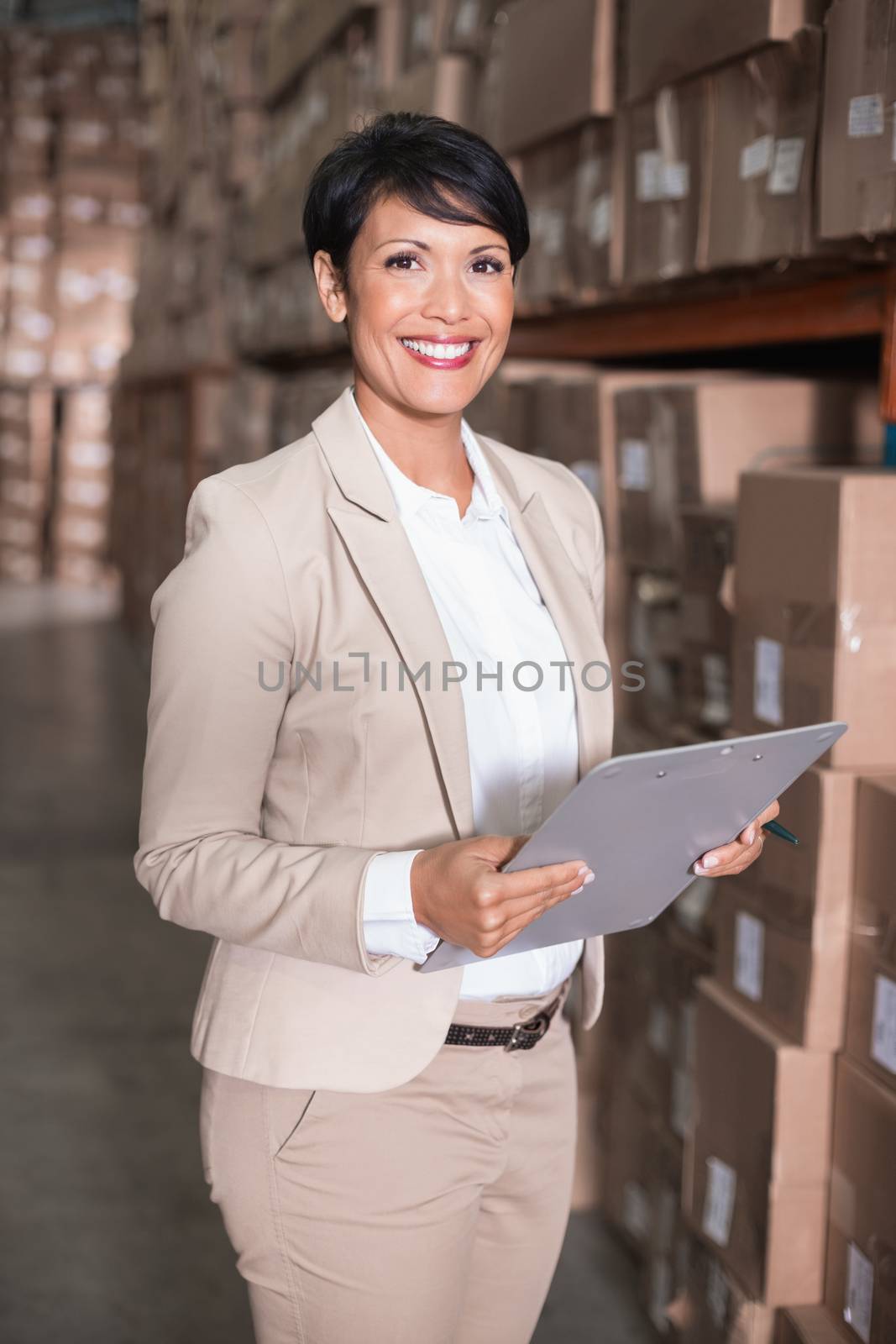 Pretty warehouse manager smiling at camera by Wavebreakmedia