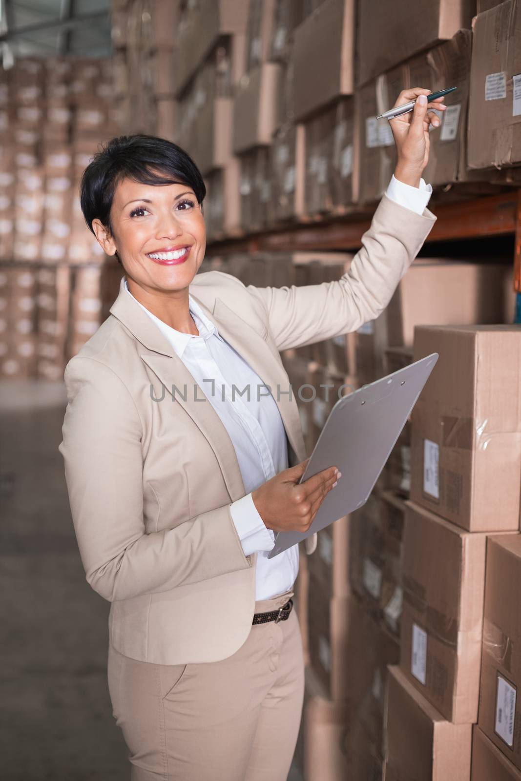 Pretty warehouse manager checking inventory by Wavebreakmedia