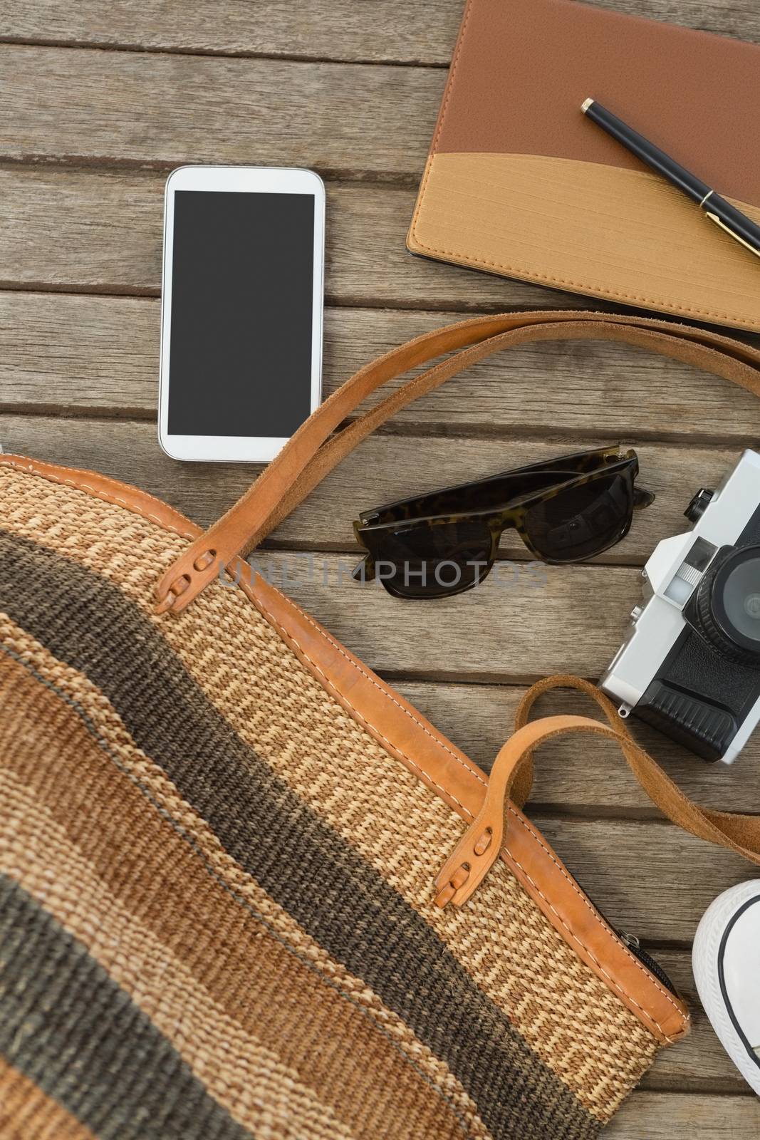 Overhead of travel accessories on wooden plank