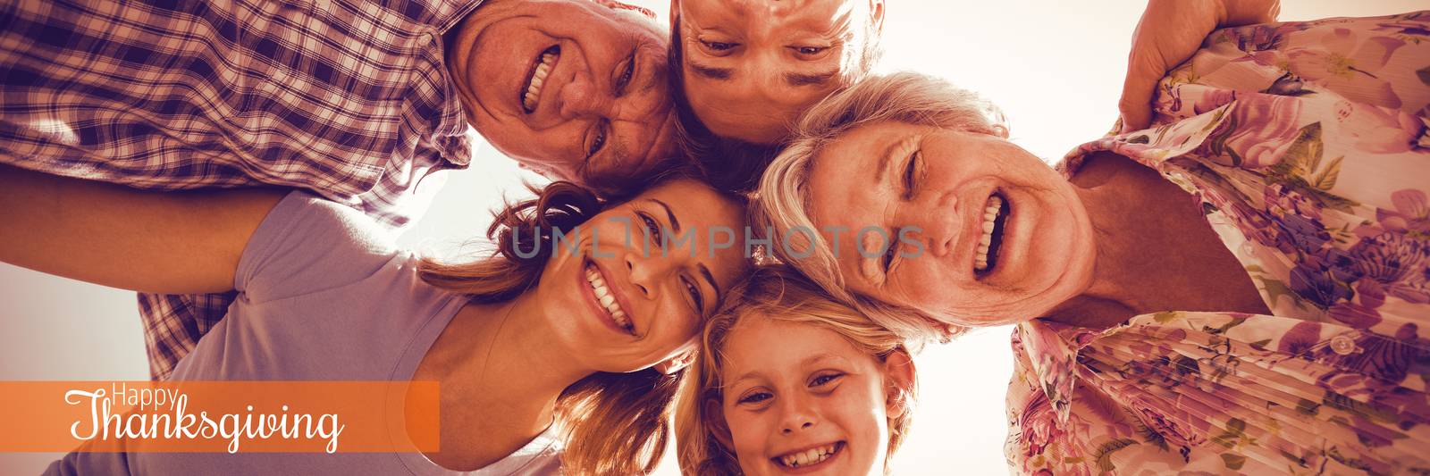 Thanksgiving greeting text against cheerful family forming huddle