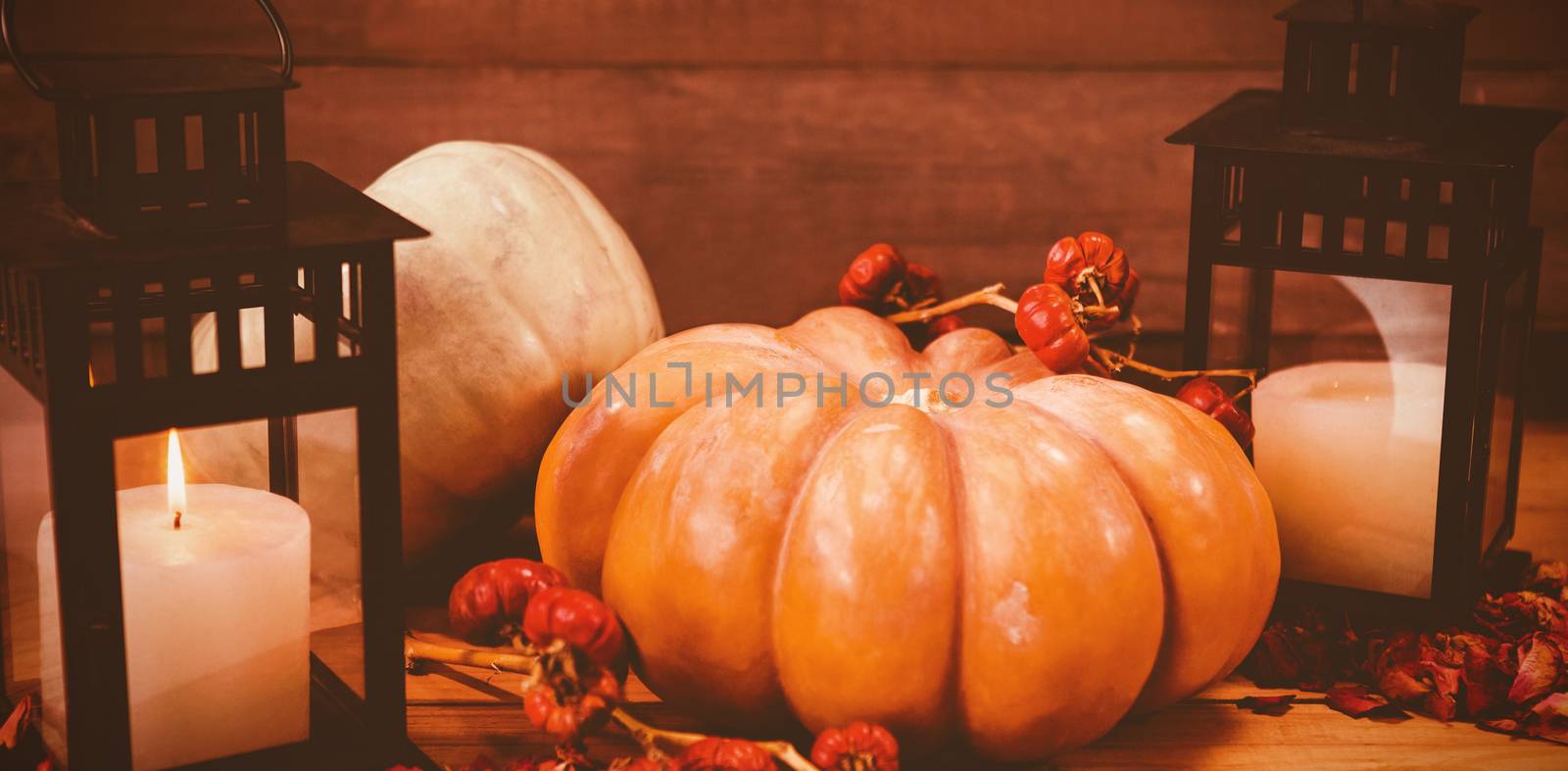 Pumpkins with candles on wooden table during Halloween