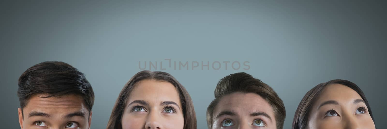 Four people looking up with grey background by Wavebreakmedia