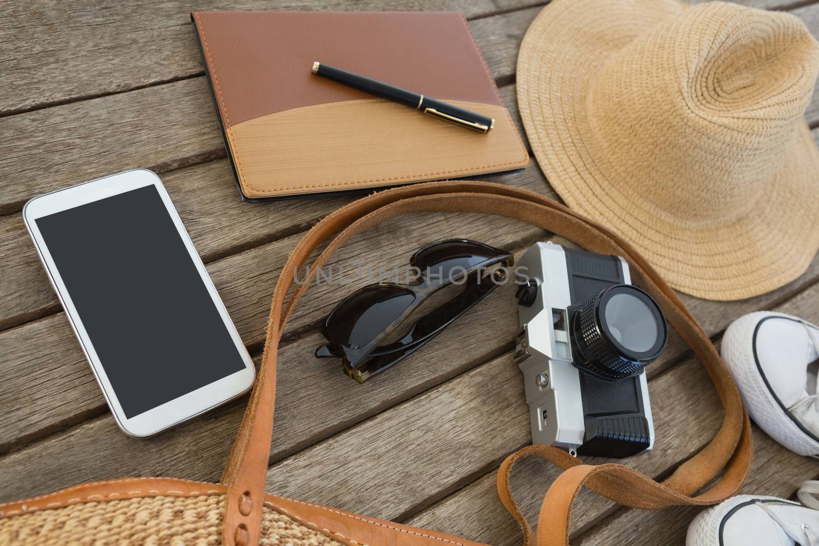 Overhead of travel accessories on wooden plank