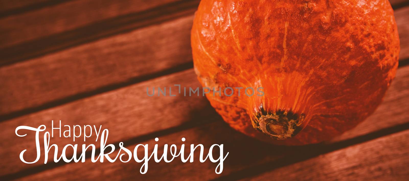 Thanksgiving greeting text against close up of squash on table during halloween