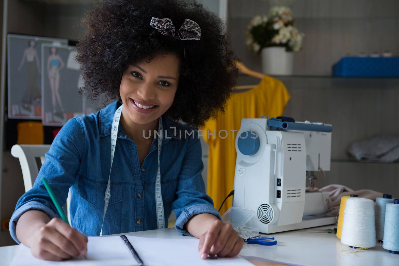 Portrait of female fashion designer working at desk