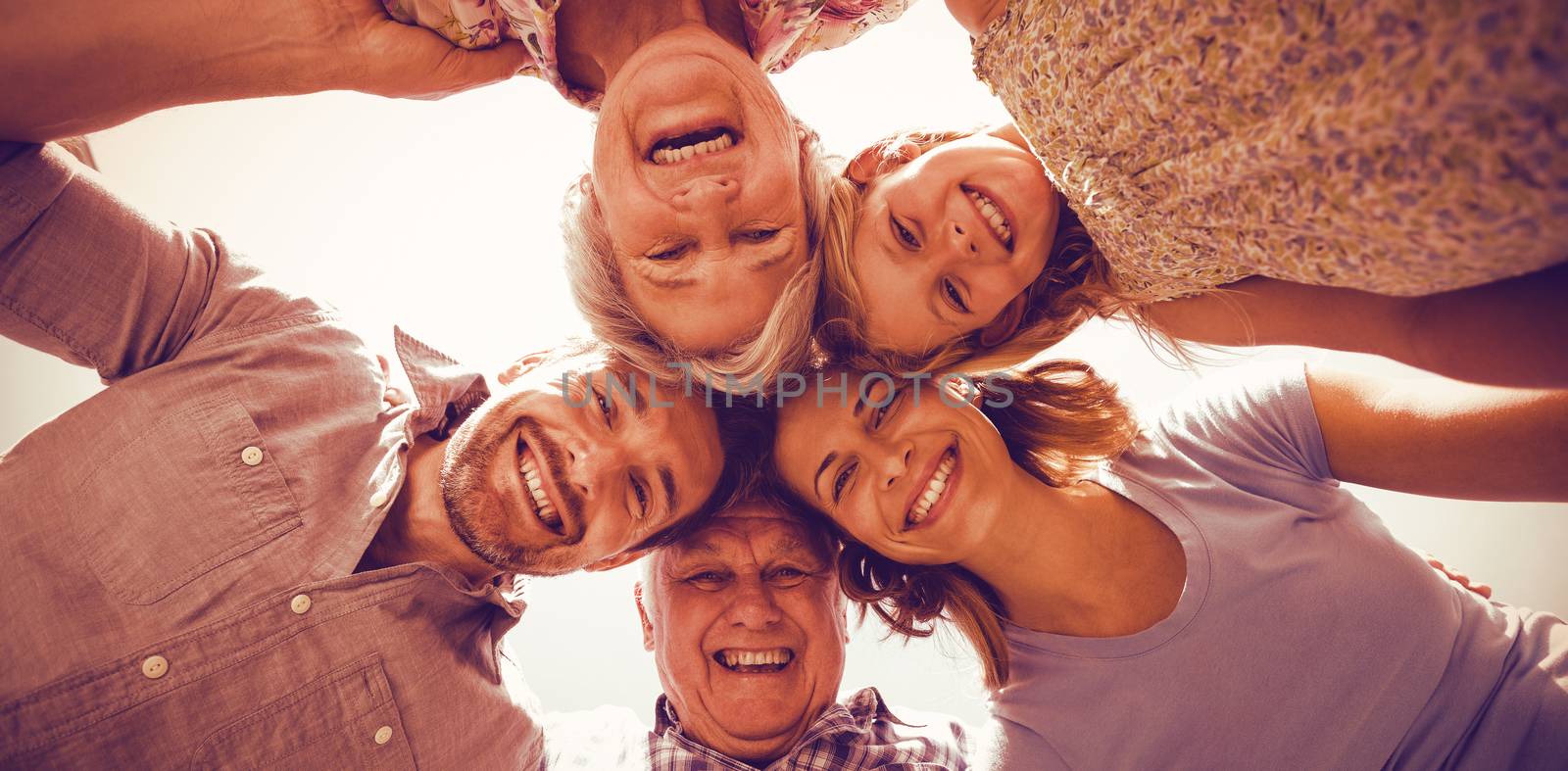 Happy family forming huddle against sky by Wavebreakmedia