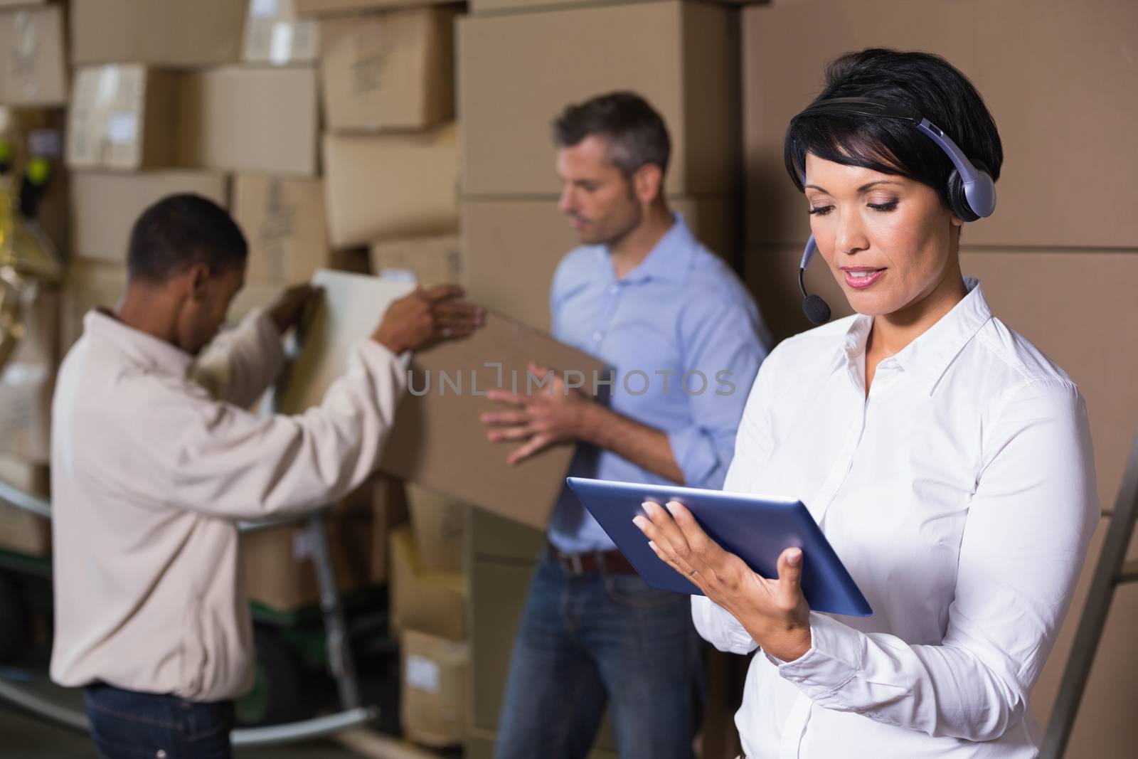 Pretty warehouse manager using tablet during busy period by Wavebreakmedia
