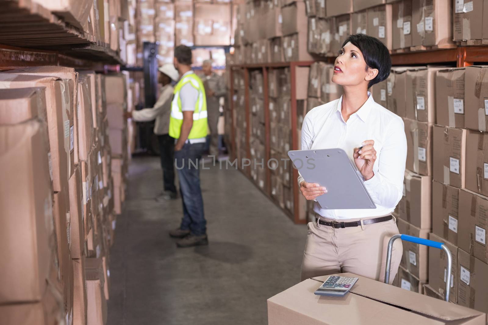 Pretty warehouse manager checking inventory in a large warehouse