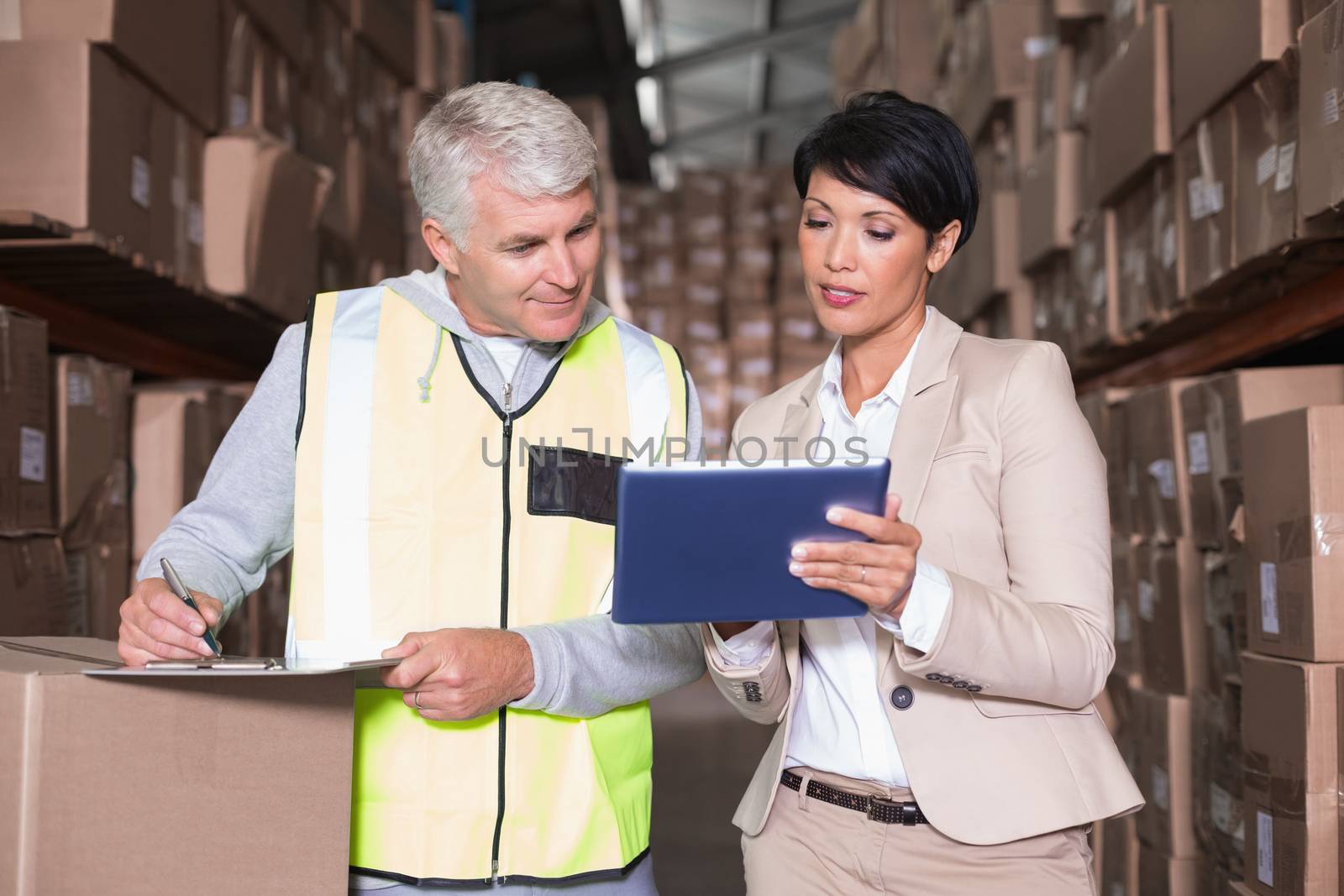 Pretty warehouse manager talking to foreman by Wavebreakmedia