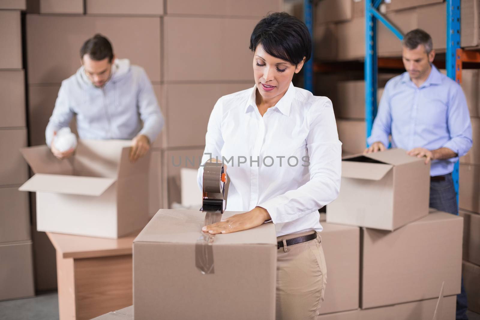 Warehouse workers packing up boxes in a large warehouse