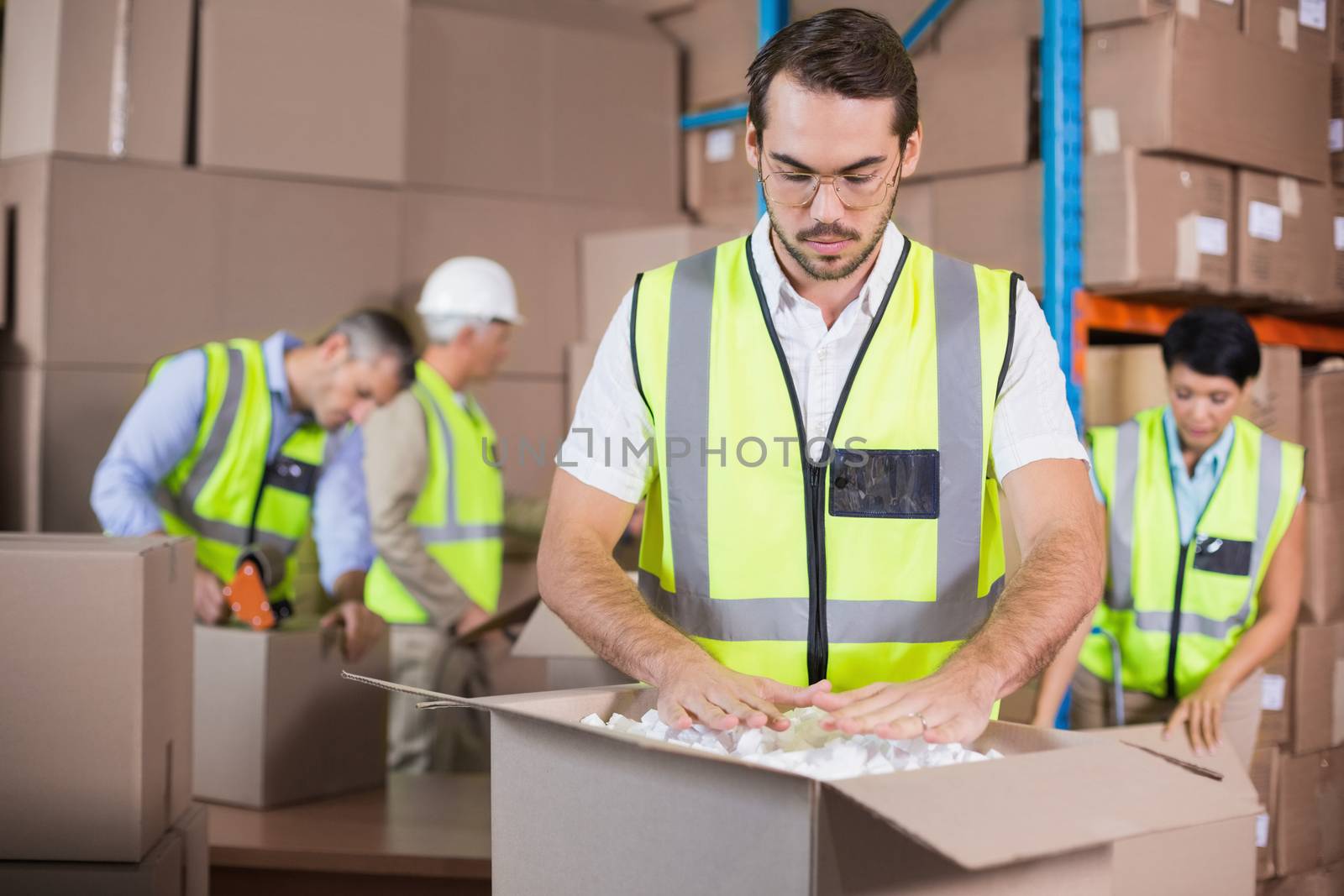 Warehouse workers in yellow vests preparing a shipment by Wavebreakmedia