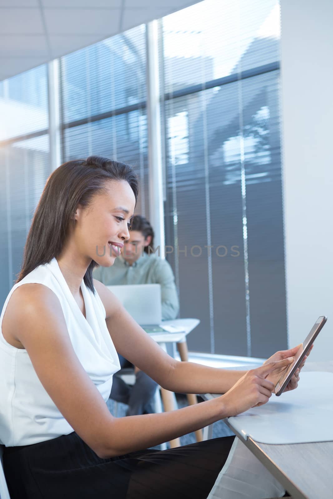 Female executive using digital tablet at desk in office