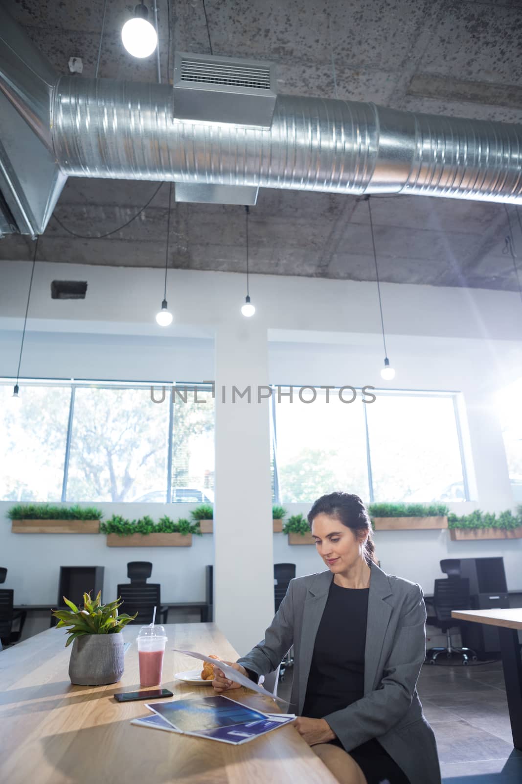 Female executive looking at documents at desk in office
