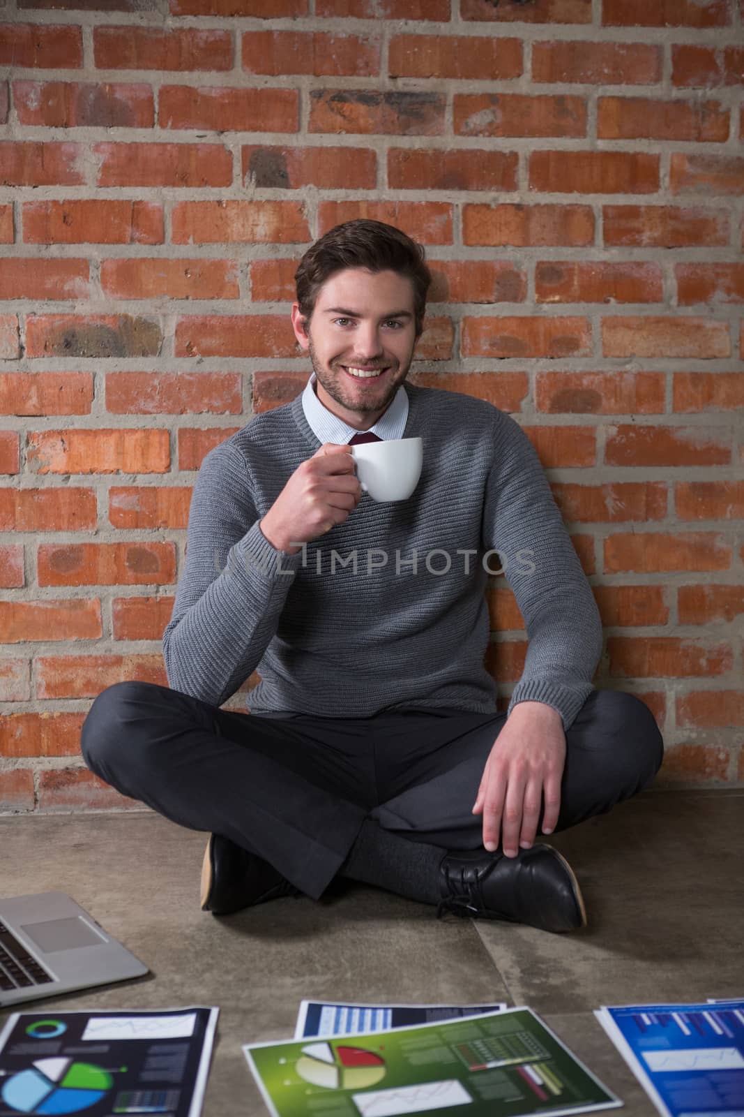Portrait of smiling executive having cup of coffee in the office