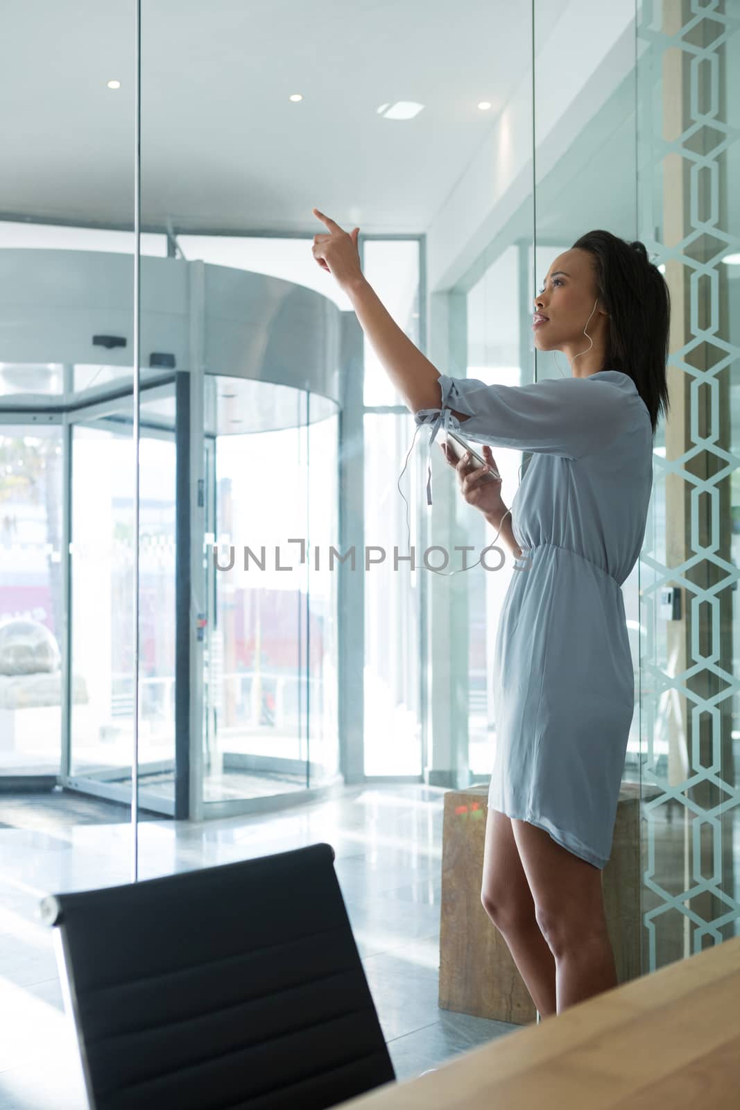Female executive using invisible digital screen in office