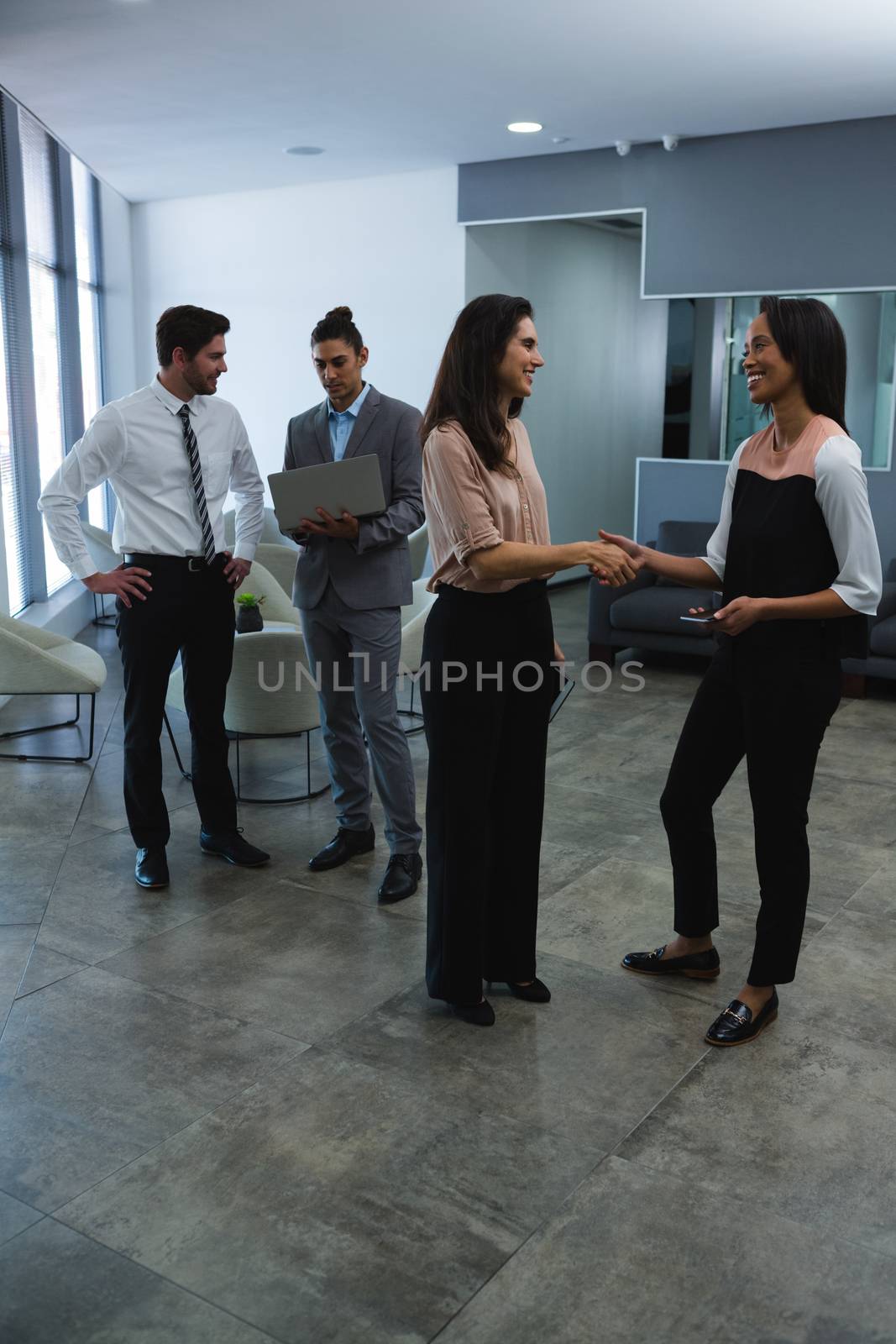 Business colleagues interacting with each other in office