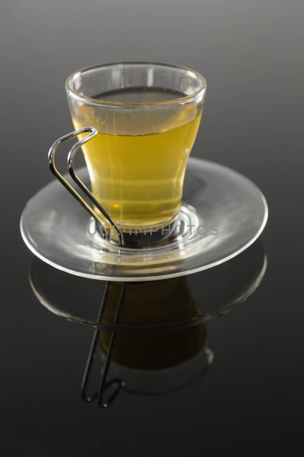 Cup of cinnamon tea on black background