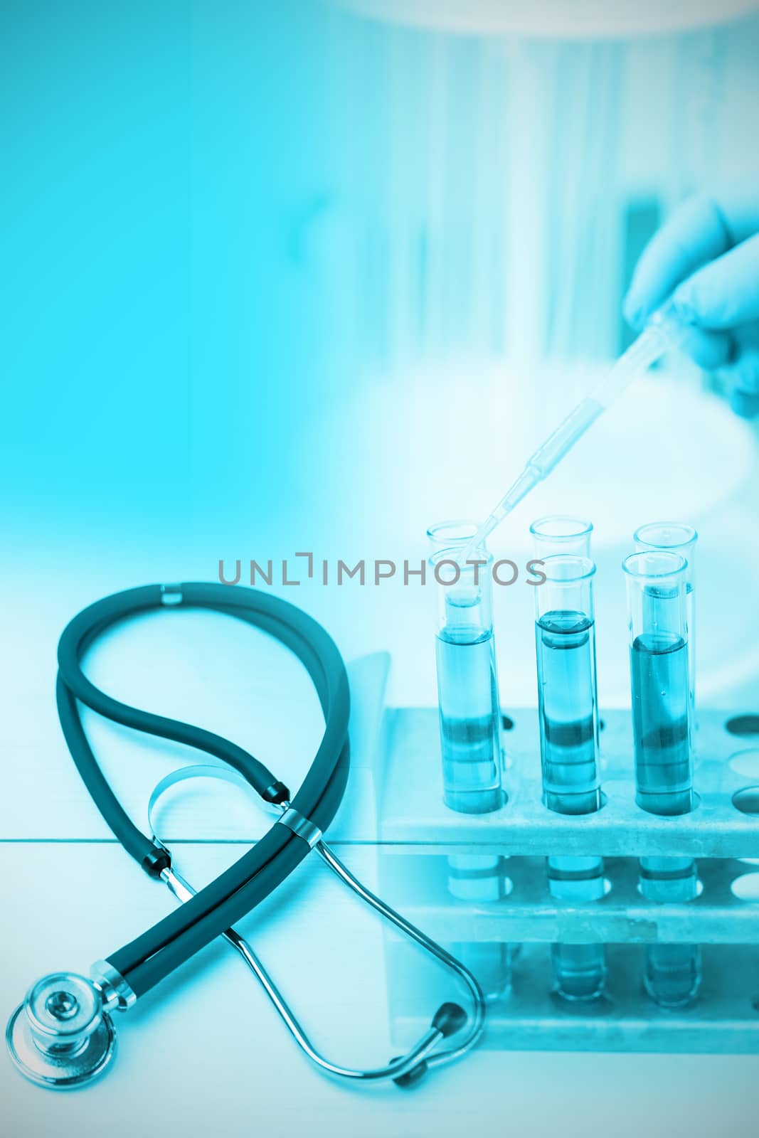 Stethoscope on desk against doctor experimenting in laboratory 