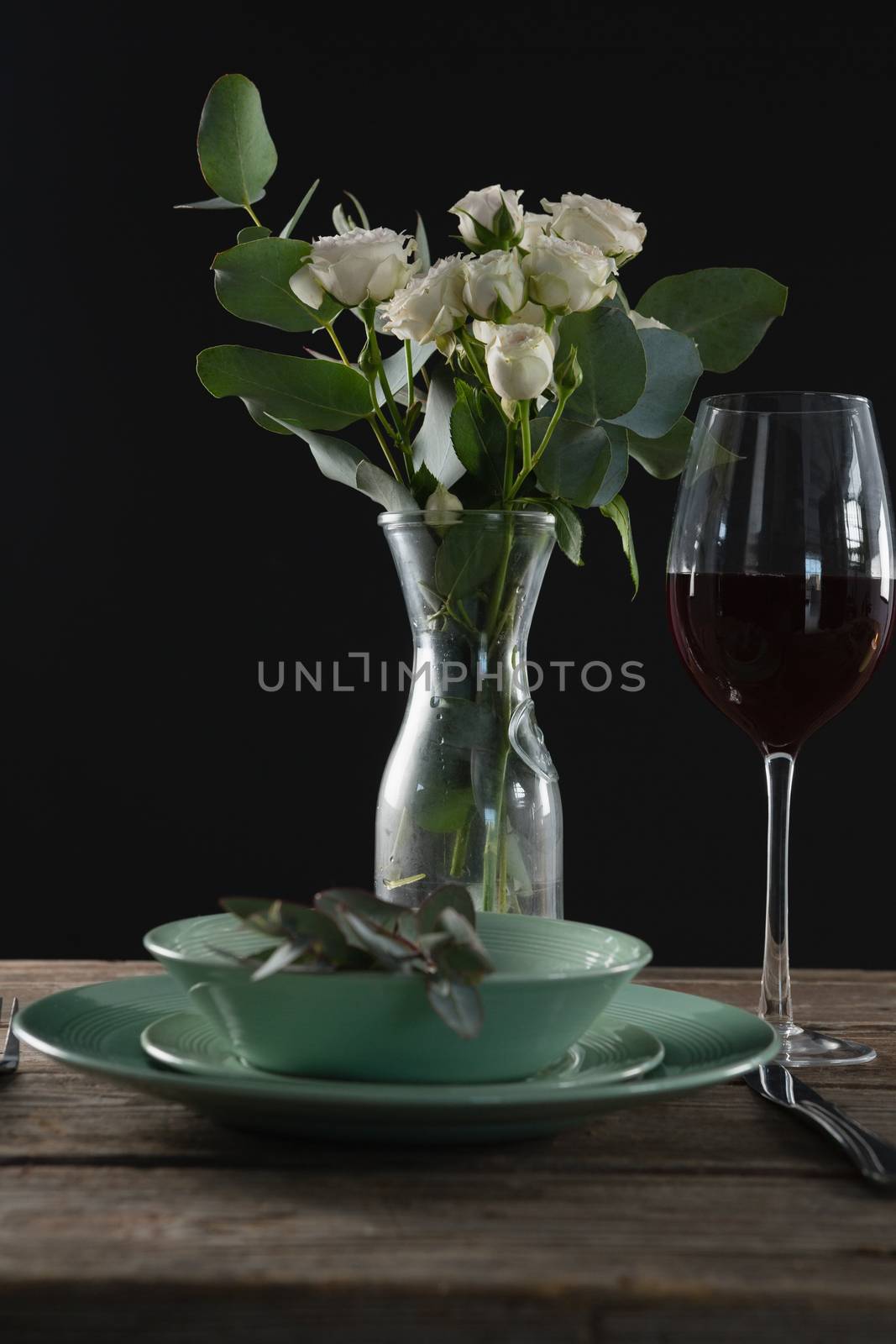 Setting a table for a dinner party with wine glass and flower vase on table