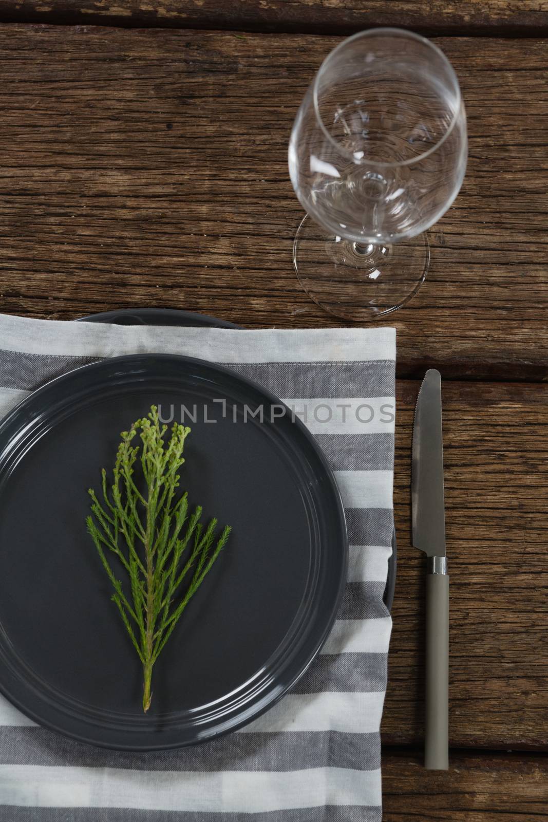 Overhead of elegance table setting with empty wine glass on wooden plank