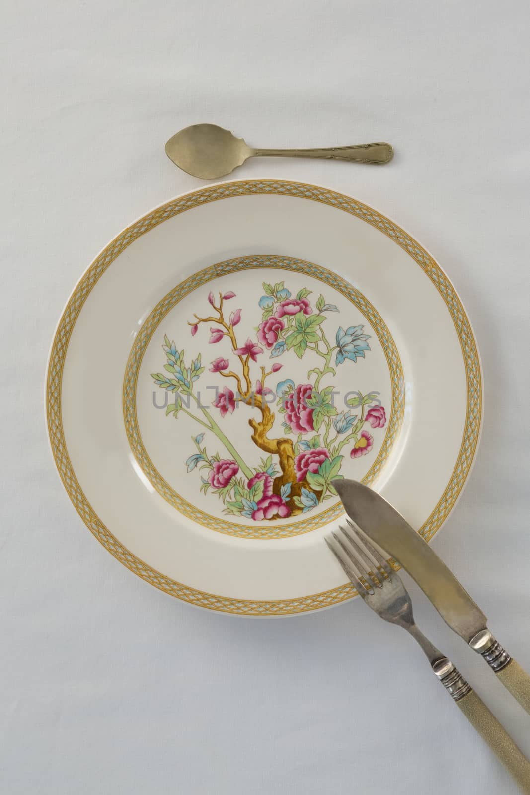 Fork, butter knife, spoon arranged in a plate