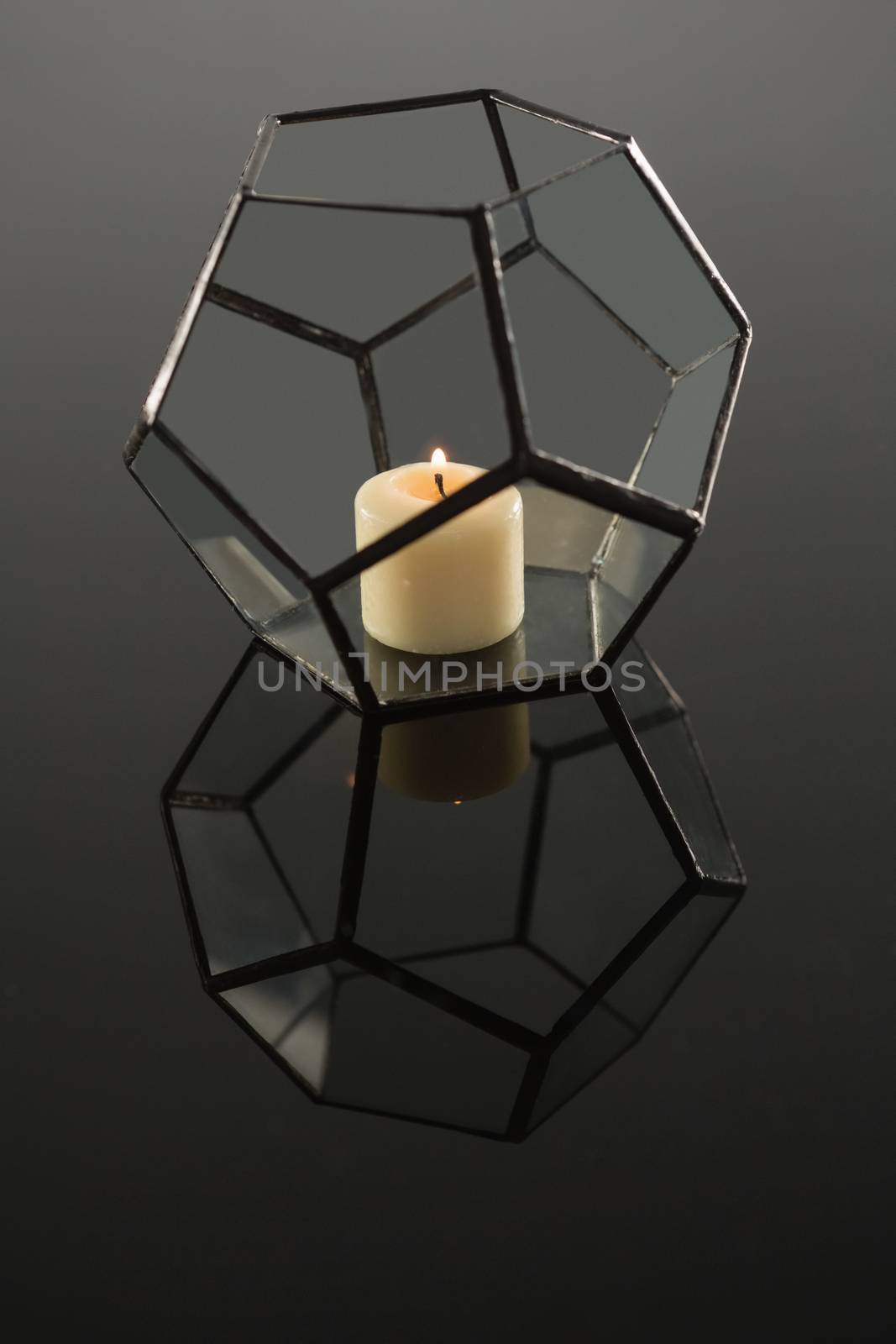 Close-up of lit candle on candle holder
