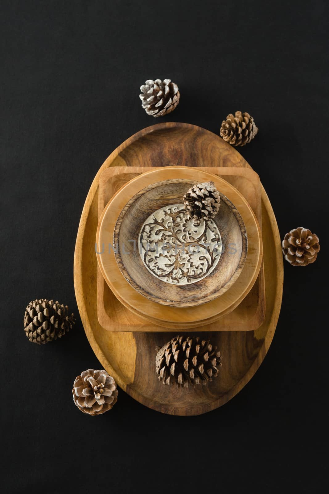 Overhead view of wooden plates set on a black themed table