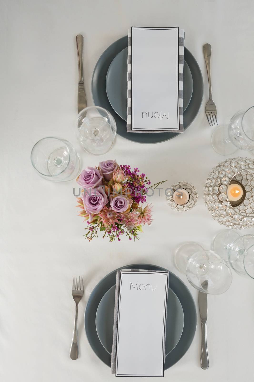 Overhead view of menu card, plate and cutlery set elegantly on a table